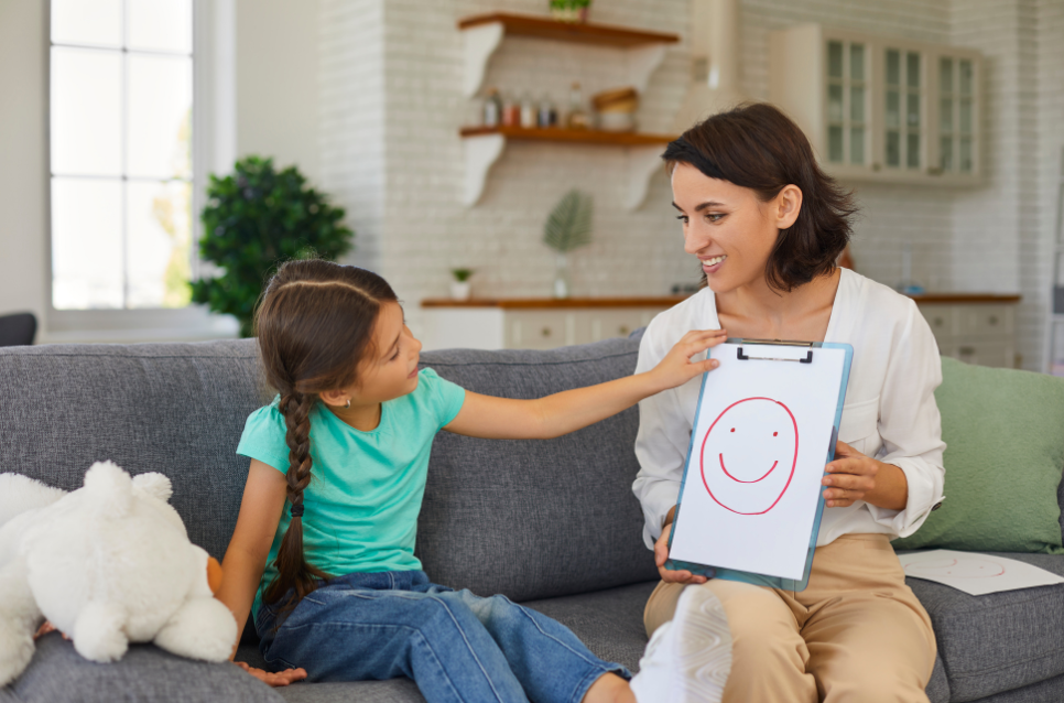 La sicurezza è un programma di vita: mamma mostra alla figlia il disegno di un volto sorridente.
